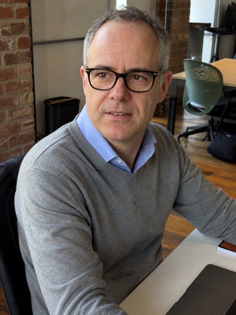 Sean Harley Chambers at his desk in London, looking up from his laptop
